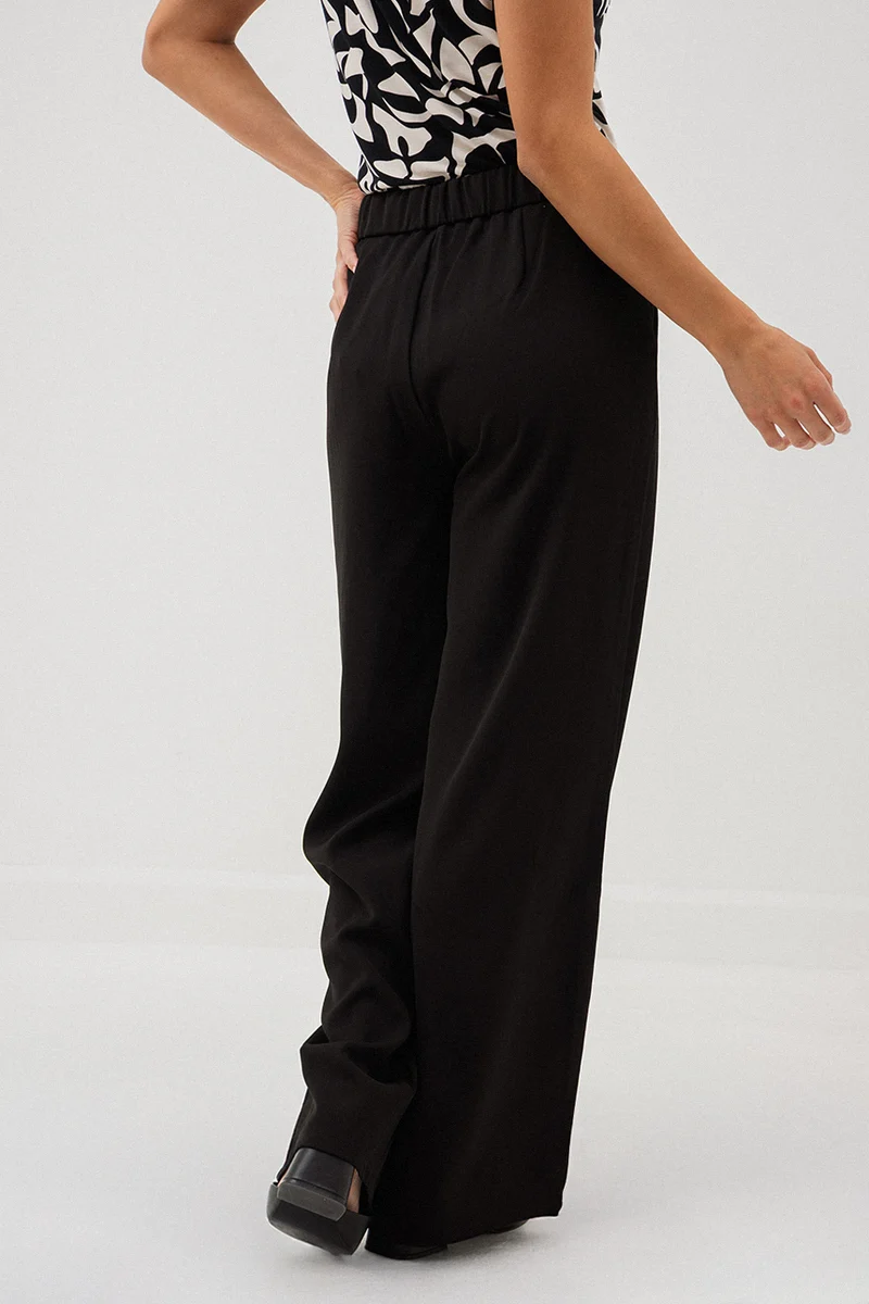 Le pantalon chic noir avec boucle à la ceinture