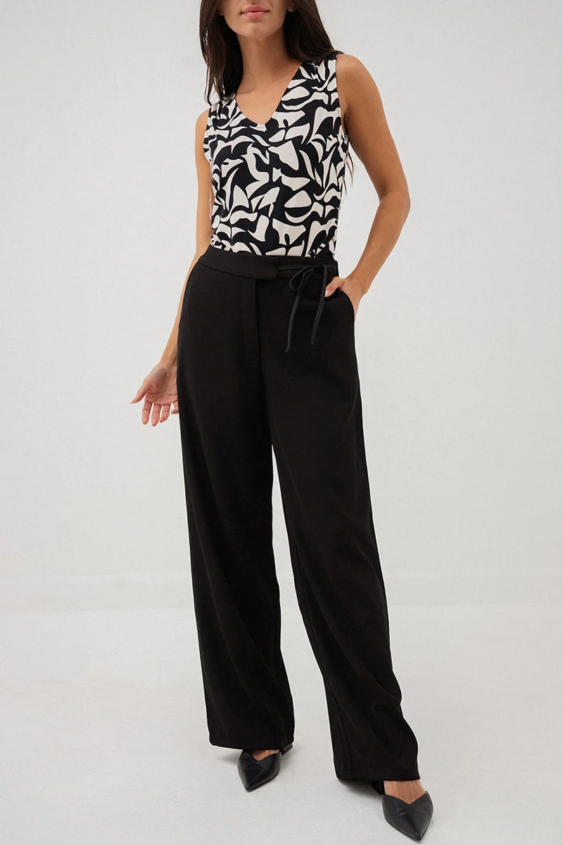 Le pantalon chic noir avec boucle à la ceinture