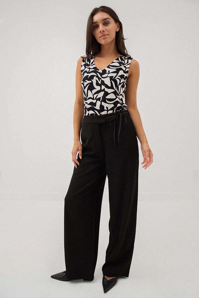 Le pantalon chic noir avec boucle à la ceinture