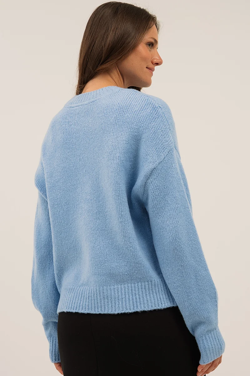 Le chandail en tricot motif de boucle à la poitrine