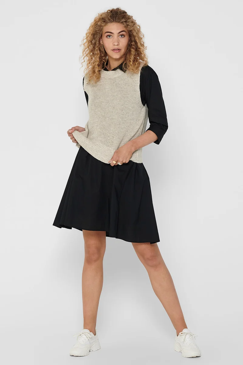 Le chandail sans manches en tricot beige