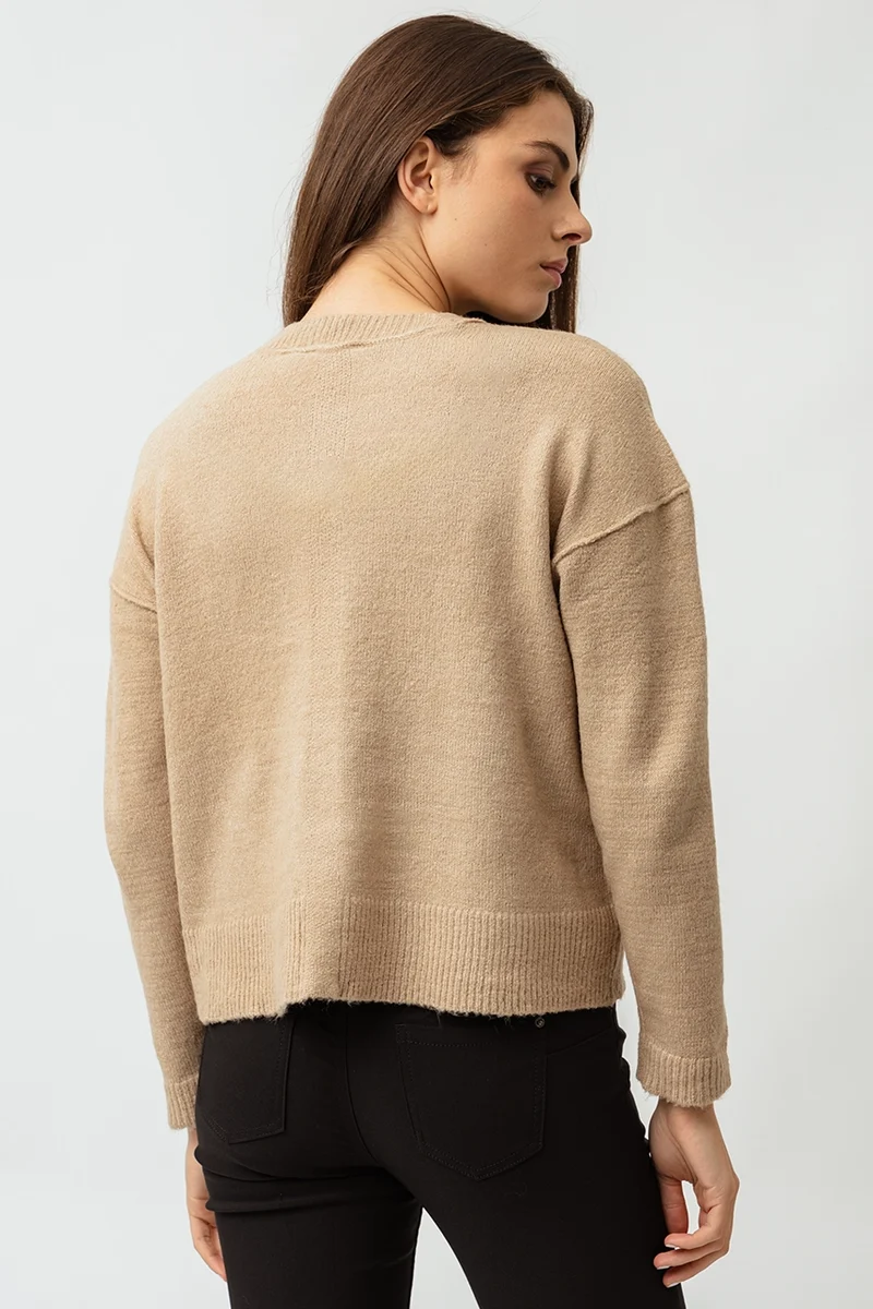 Le chandail en tricot coutures apparentes