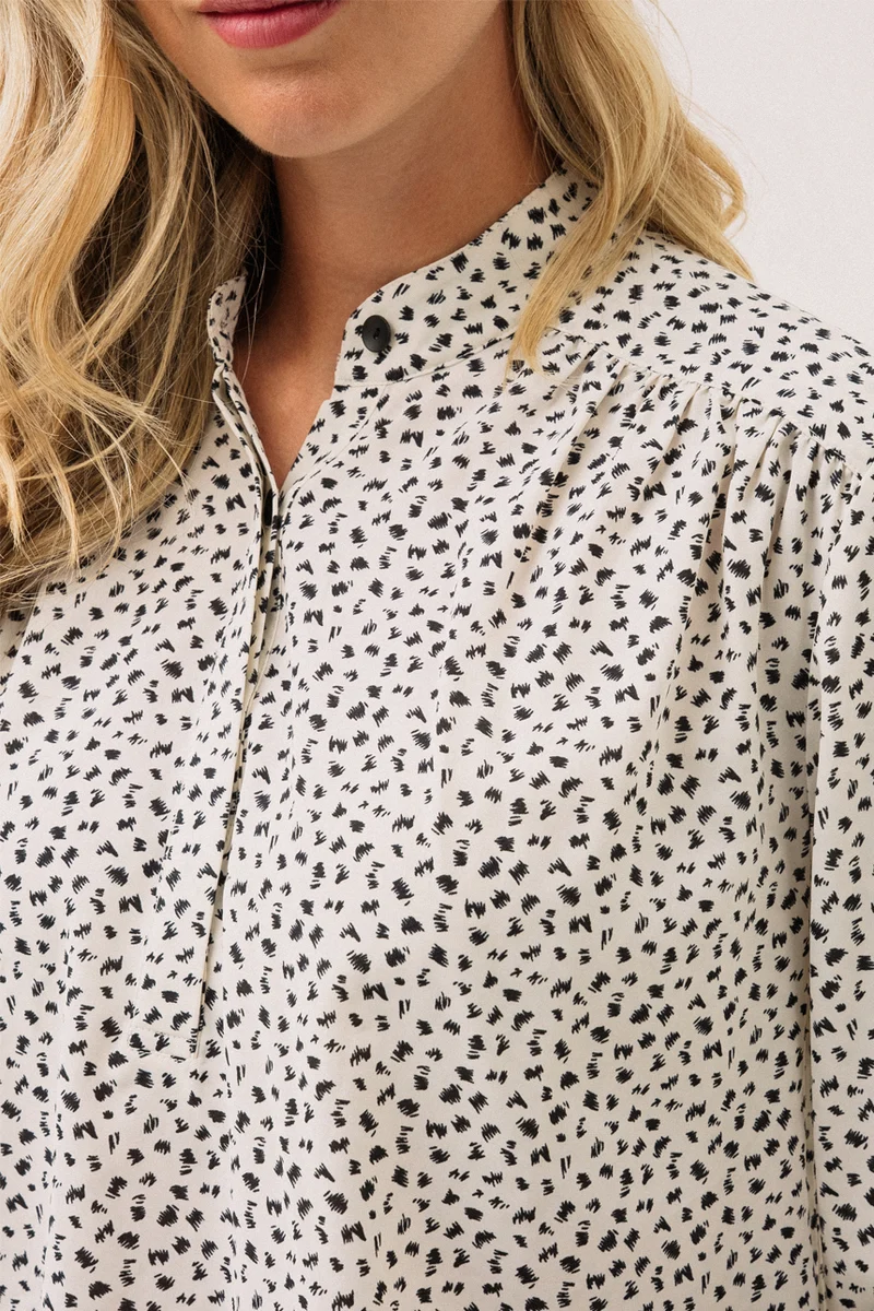 La blouse à motif abstrait blanc et noir